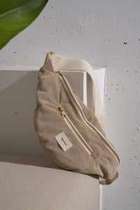 sac banane velours côtelé beige sur un fauteuil
