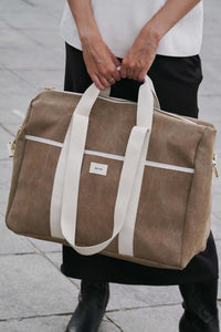 sac de voyage effet cuir porté par une femme
